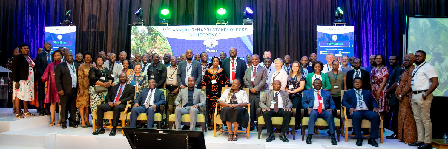 a long photo shows many people on a stage with a large banner that reads 9th Annual Stakeholders Conference.